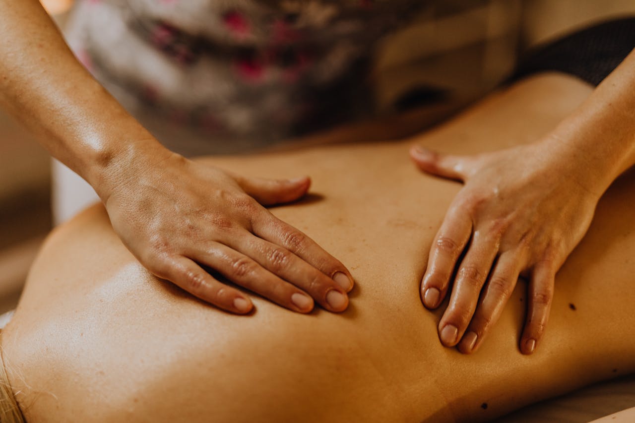 Close-up of hands giving a soothing back massage in a calm setting.